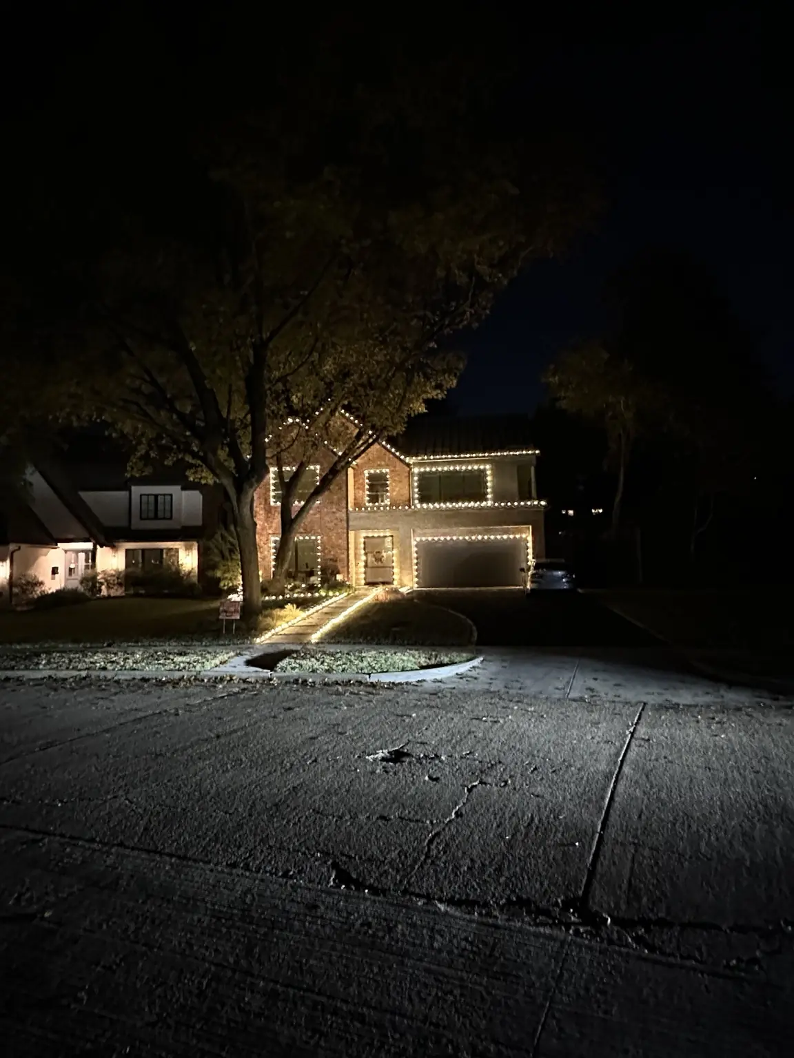 Lakewood Christmas Light Installation | Elf's Christmas Lights Wide nighttime view of a Lakewood brick home with warm-white architectural Christmas lights