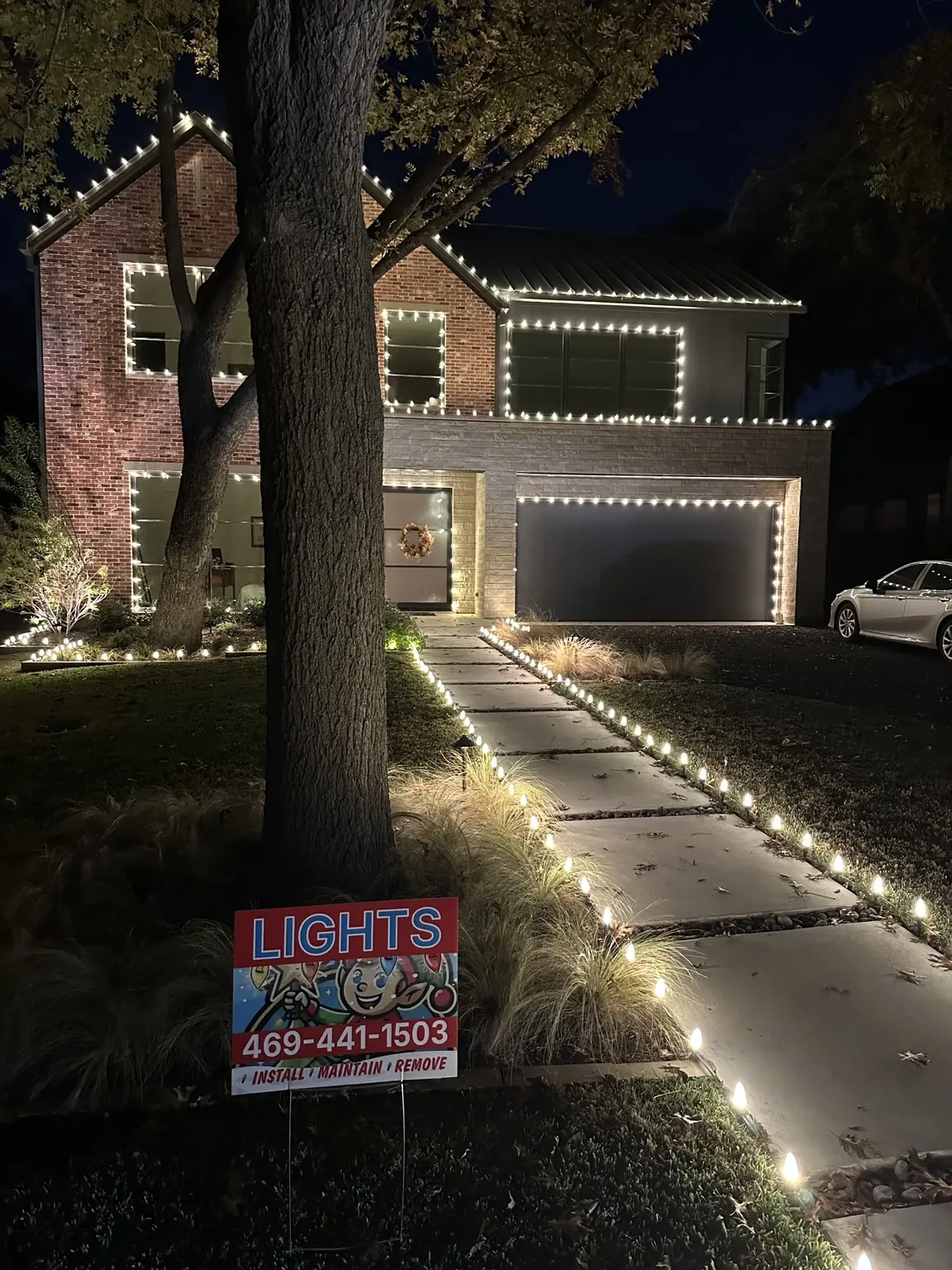 Modern Lakewood brick home transformed with warm-white roofline, window and walkway Christmas lights