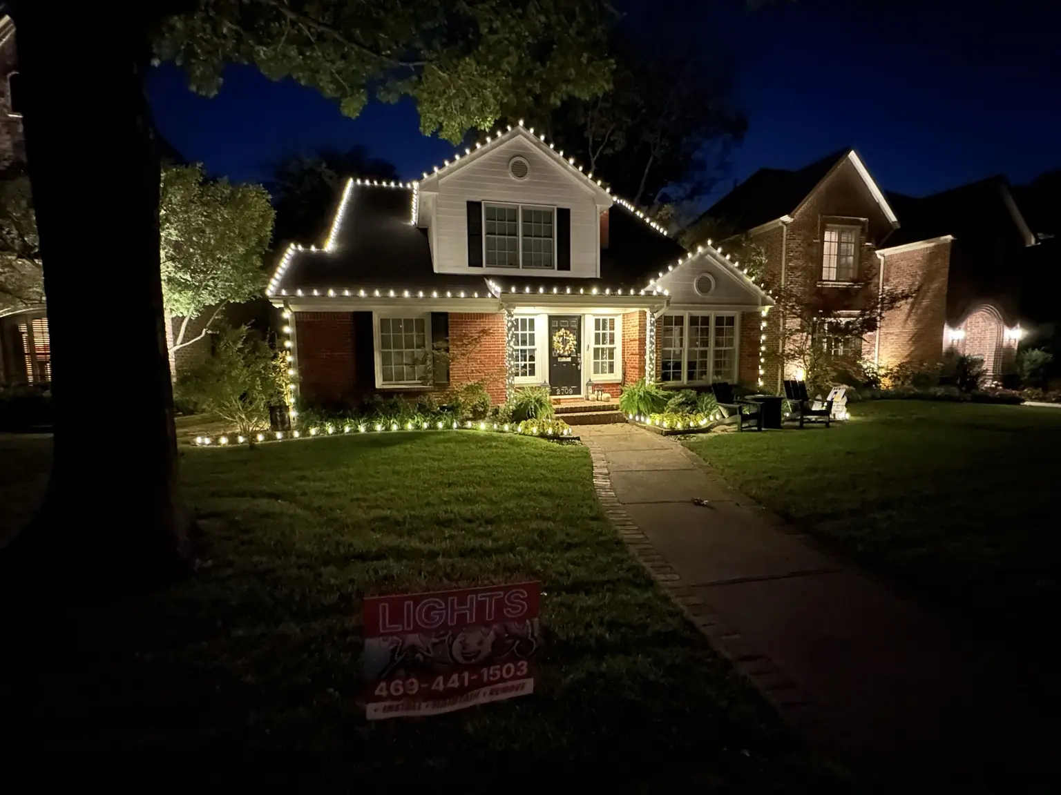 Traditional home with professionally installed warm-white roofline and landscape Christmas lights